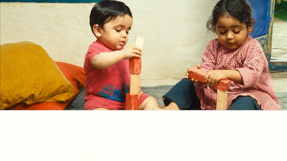 Lakri ke blocks ke saath mil kar khelte do bachon ka illustrative AI-generated manzar